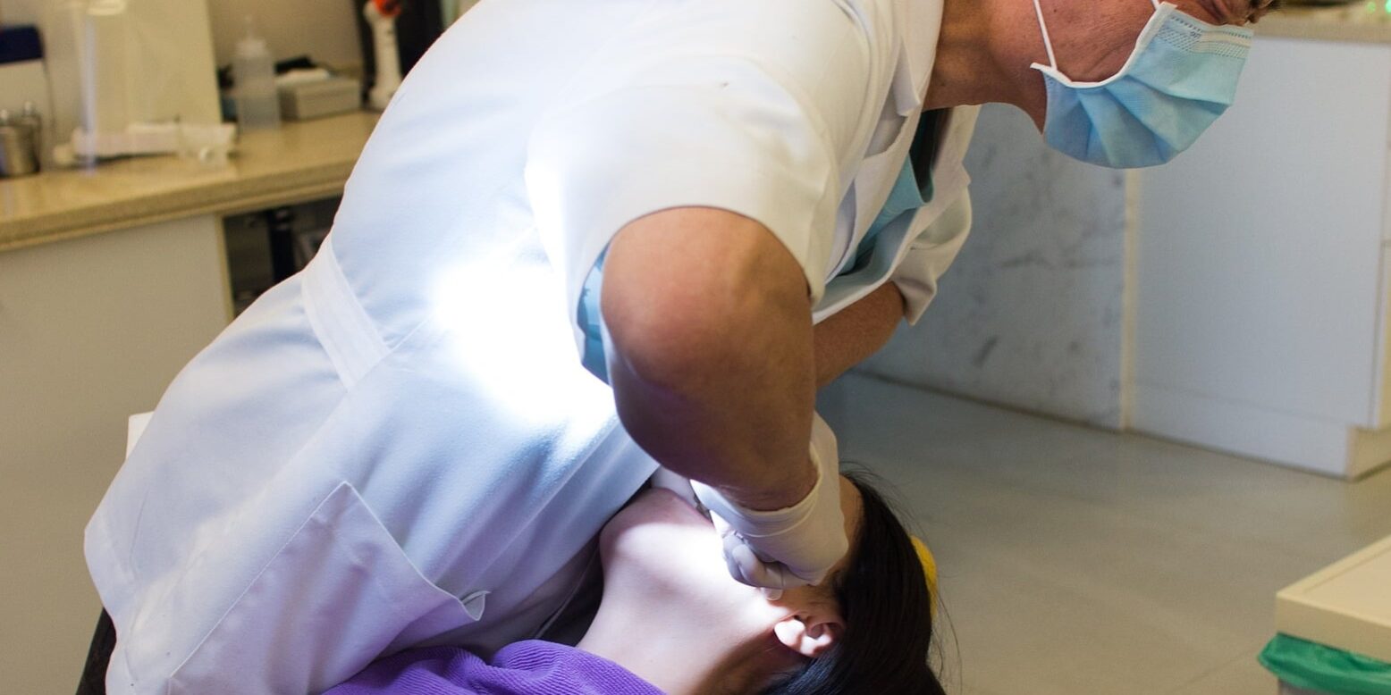 Dentist performing tooth extraction in dental clinic, representing dentists and tax concerns