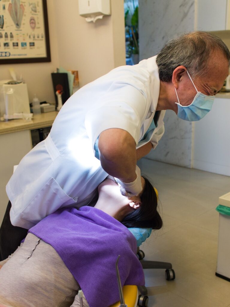 Dentist performing tooth extraction in dental clinic, representing dentists and tax concerns